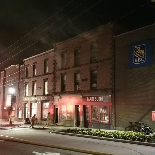 Smoke is seen coming out of the third story of a three story brick building on Bridge Street in Sackville, NB.