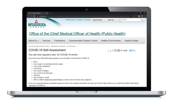 A laptop is open and the Government of NB website is shown on the screen. The web page says "The Office of the Chief Medical Officer of Health. COVID-19 Self-Assessment."  