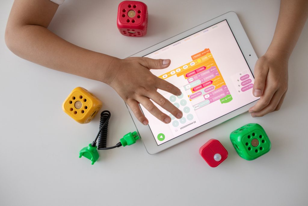 A child plays with an iPad on a table.