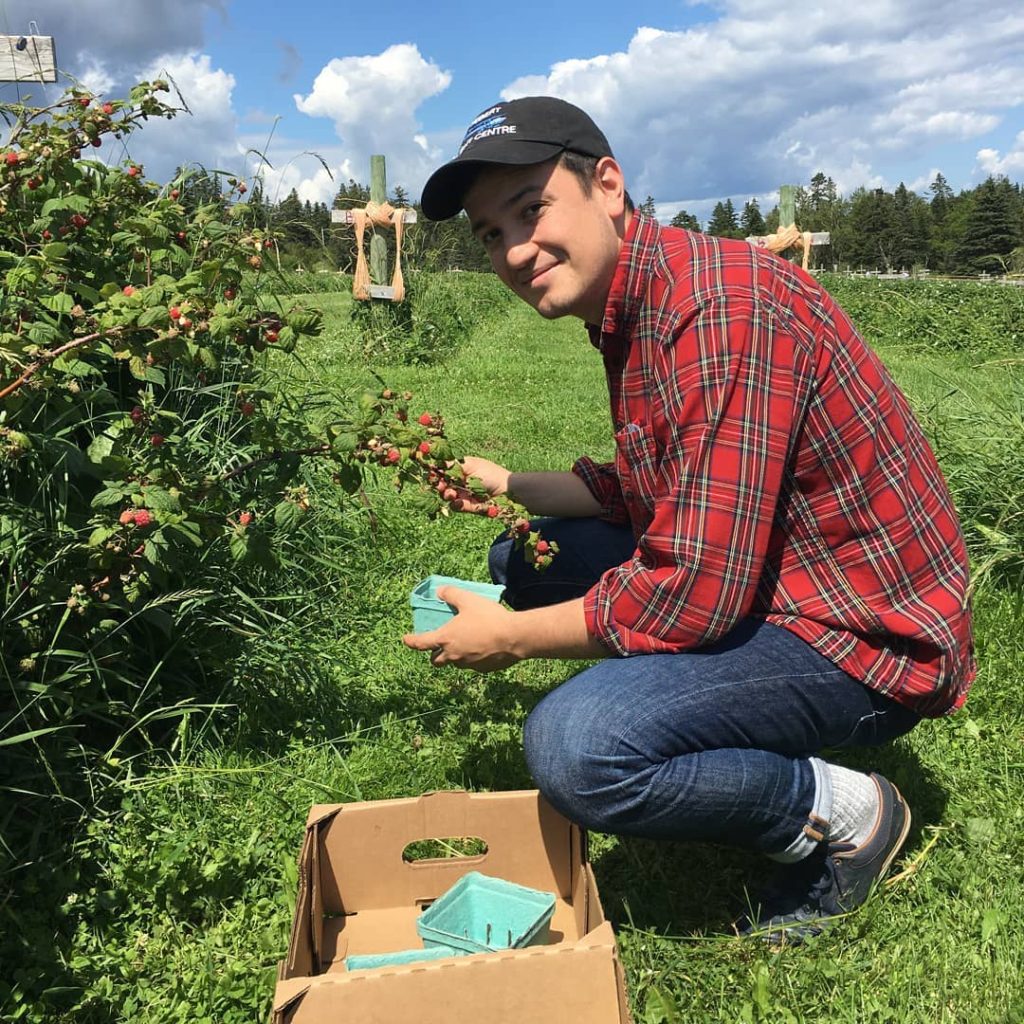 Juan Facundo picks berries outdoors.