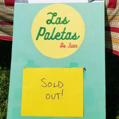 A sold out sign in front of a booth outside.